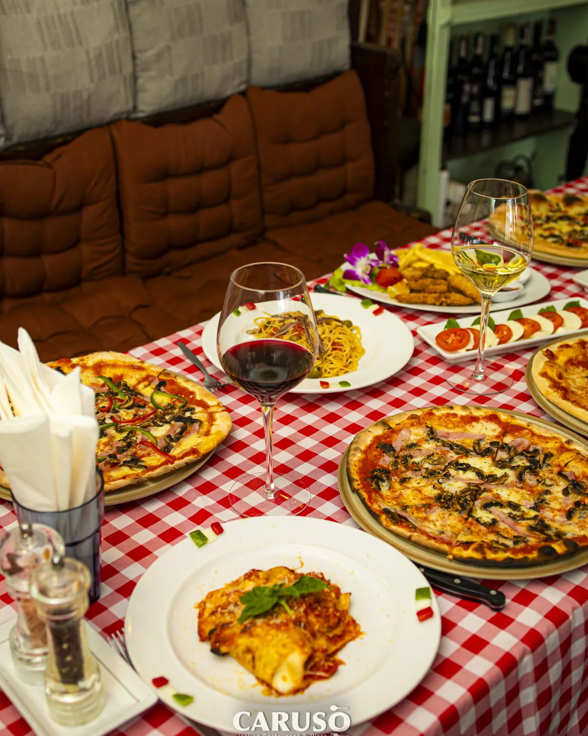 Pizza, pasta and wine on a table at Caruso Hua Hin