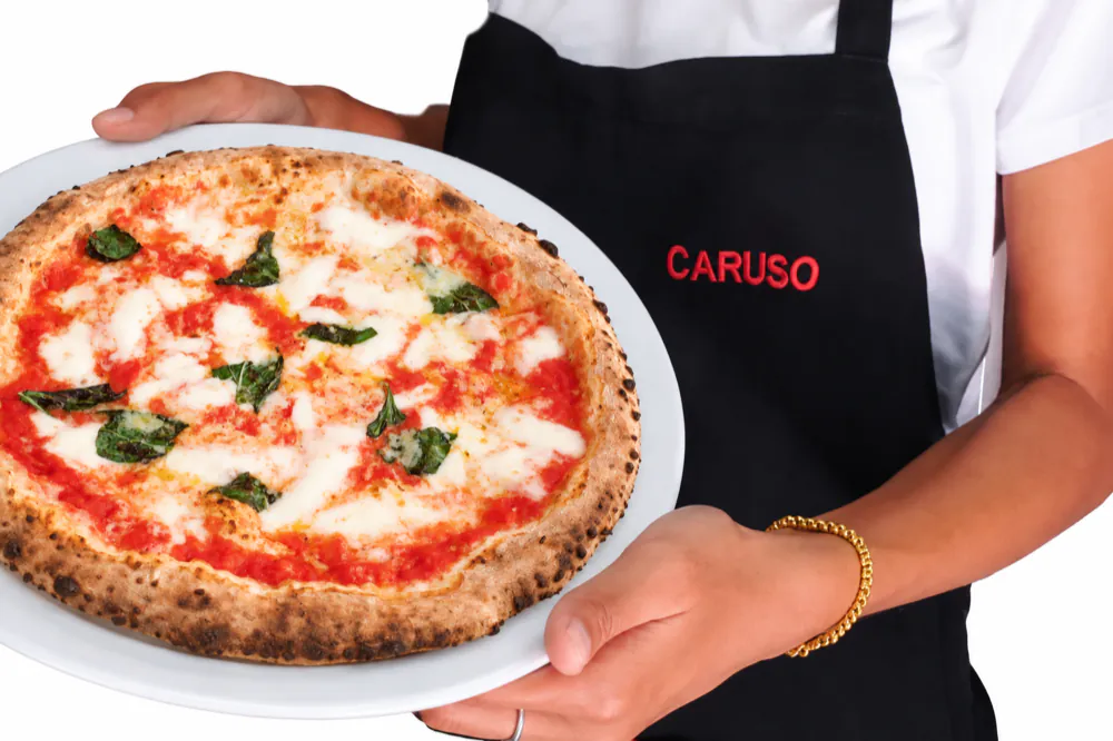 Pizza Margherita served by a Caruso waiter